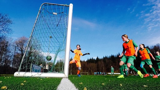 Torhüterin Anna Louisa versucht einen Ball der gegenerischen Spielerinnen zu halten, der jedoch ins Netz geht.