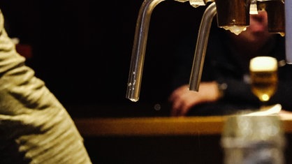 Bier tropft aus einem Zapfhahn in einer Kneipe. 