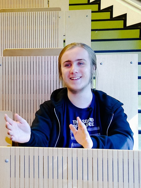 Jonathan Bork lächelt und sitzt in einem Hörsaal