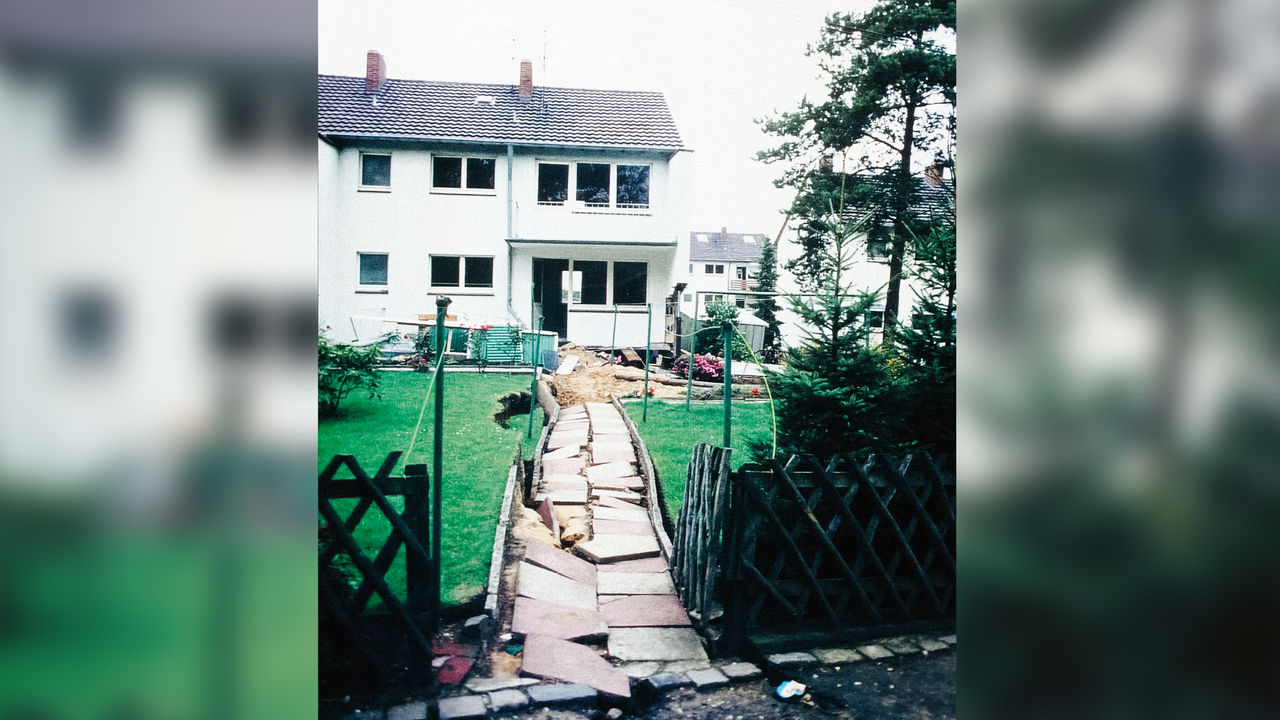 Der Weg zu einem Haus, die großen Fliesen liegen völlig durcheinander. 