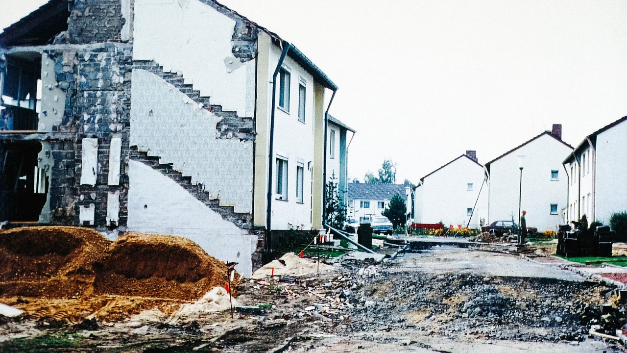Eine völlig aufgerissene Straße, bei einem Haus daneben fehlt eine Wand.