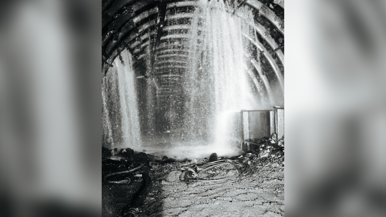 Der Blick in einen Stollen, von oben fließt Wasser in Strömen von der Decke.