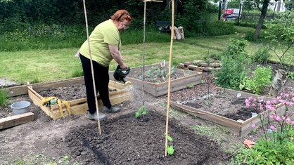 Uschi Peters steht in ihrem Garten