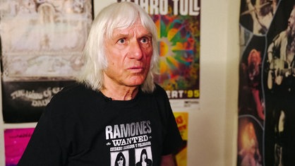 Nahaufnahme von Gerd Solty, ein Mann mit langen weißen Haaren und einem schwarzen T-Shirt.