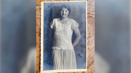 Historisches Portrait eines Mädchens. Sie hält die Hände hinter dem Rücken zusammen.