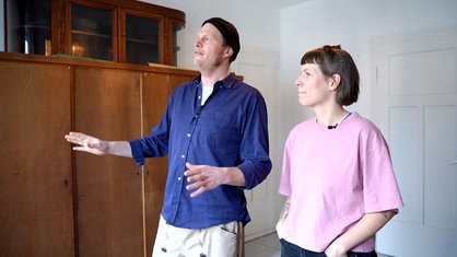Katrin und Lukas Mokros blicken auf ein Fenster, die Fundstelle des Briefs.