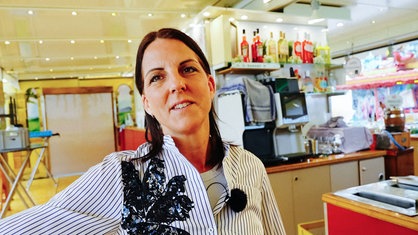 Ute Lemoine steht in ihrer Kirmesbude
