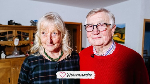 Heidi und Horst stehen eng nebeneinander und lächeln Richtung Kamera