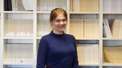 Verena Krautwald, eine junge Frau vor einem Bücherregal.