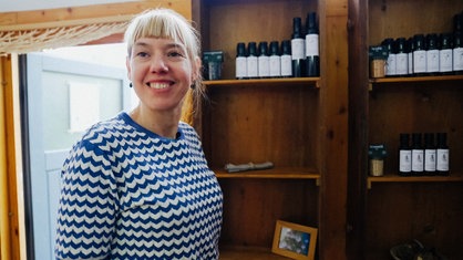 Jördis Boemke steht vor einem Regal mit Ölflaschen