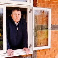 Eine Frau lehnt sich aus einem Fenster und blickt suchend hinaus