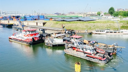 Zwei Schleppschiffe ziehen das historische Dampfschiff "Oscar Huber" über das Wasser in die Werft.