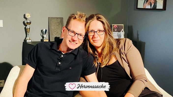Simone und Daniel lächeln nebeneinander in die Kamera.