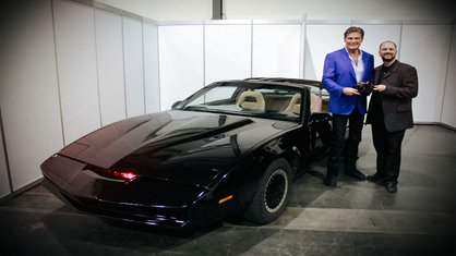 Autogramm-Sammler Lars Giesen steht neben Schauspieler David Hasselhoff und einem KITT-Sportwagen