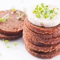 Geschnittener Pumpernickel garniert mit Frischkäse und Kresse