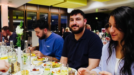 Enes Türedioğlu mit Freunden am Tisch in der Mensa