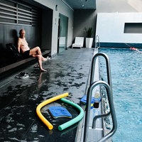 Harald Peter sitzt an einem Schwimmbecken und lacht.