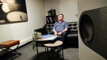 Eckard Jagalla sitzt mit geschlossenen Augen auf einem Sofa.