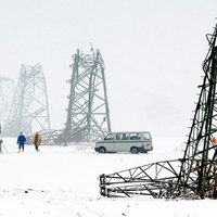 Umgeknickte Strommasten in einer verschneiten Landschaft