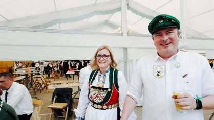Ana und Sascha Radermacher in ihren Schützenfest-Trachten. Sascha hält ein Glas Bier in der linken Hand.