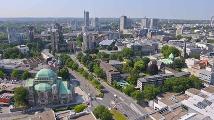 Aussicht auf die Stadt Essen vom Rathaus aus, im Vordergrund unter anderem die Alte Synagoge und der Essener Dom, im Hintergrund mehrere Hochhäuser.