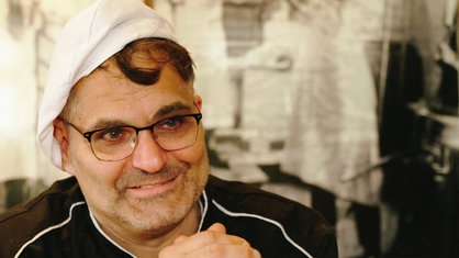 Jörg Liese trägt eine Bäckermütze und schaut an der Kamera vorbei.