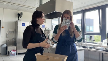 v.l. Tabea Herde und Stine Lühring riechen an unterschiedlichen Hopfensorten.