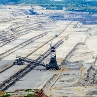 Ein Loch aus abgegrabenem Boden, in dem drei Braunkohle-Bagger stehen