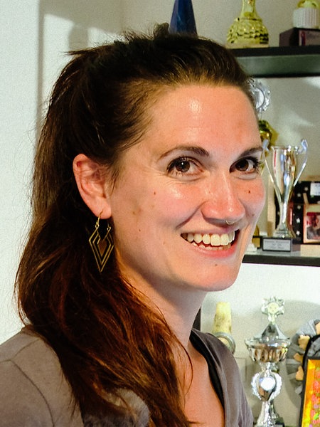 Maura Porrmann vor einem Regal, gefüllt mit dutzenden Pokalen