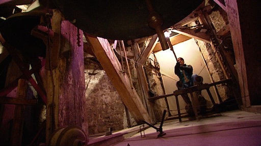 Ein Mann zieht an einer großen Glocke