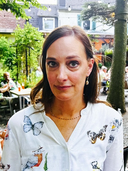 Die Wirtin Julia Söhngen steht in dem Biergarten ihrer Kneipe "Kastanie am Hax"