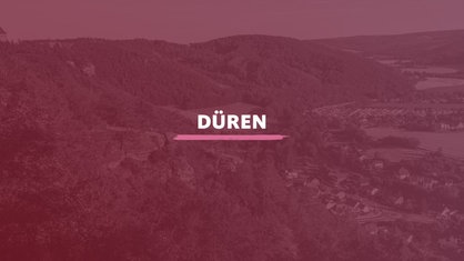 Hügelige, bewaldete Landschaft. Darauf der Schriftzug "Düren".