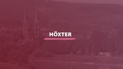 Der Blick Kilianikirche am Ufer der Weser. Darauf der Schriftzug "Höxter".