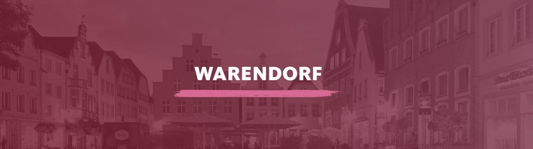 Marktplatz der historischen Altstadt in der Abenddämmerung. Darauf der Schriftzug "Warendorf".