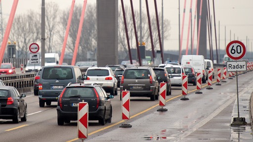 Autos die auf einer zweispurigen Straße über die Rheinbrücke fahren.