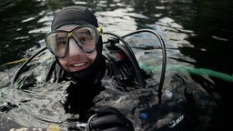 Ein Mann ist in Tauchausrüstung an der Wasseroberfläche