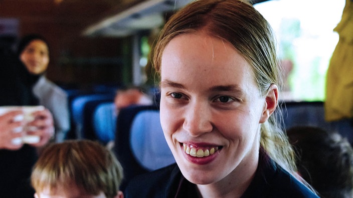 Die junge Laura Seekamp steht im Mittelgang eines Zuges. 