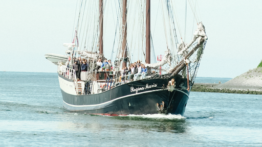 Mit der Crew und den Schülern an Deck läuft das Segelschiff Regina Maris in den Hafen von Amsterdam ein