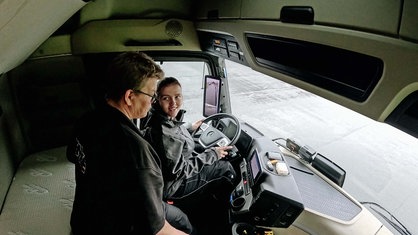 Lea Meyer sitzt am Steuer eines LKW. Sie lächelt Tanja Sieling an. Die steht neben ihr.