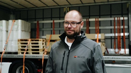 Ausbildungsleiter Ingo Schrader. Er steht vor einem offenen LKW.