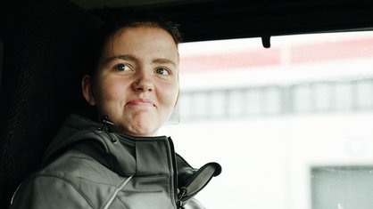 Lea Meyer sitzt auf dem Fahrersitz eines LKW. Sie lächelt.