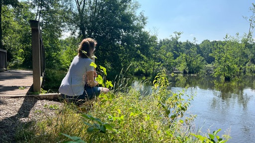 Eine Frau schaut auf den Borner See