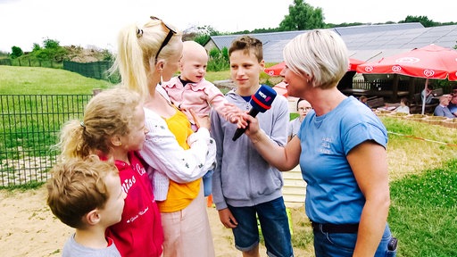 Gina Niemeier, Moderatorin der Lokalzeit, interviewt eine Familie.