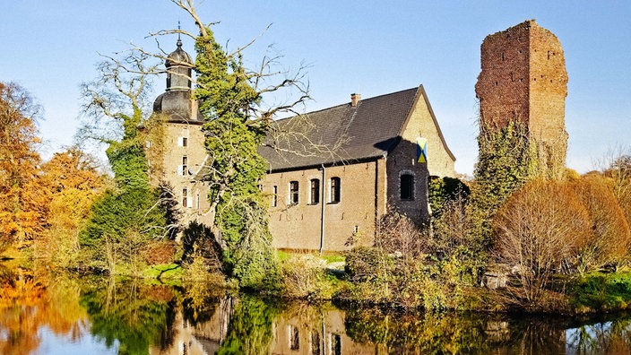 Das Schloss Tüschenbroich mit seinen alten Mauern am Wasser.
