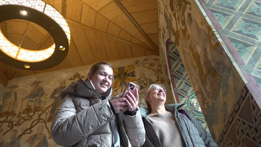 Mädchen und Mutter mit Handy im Rittersaal
