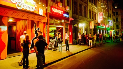 Eine Barmeile in Köln: Es befinden sich viele Menschen vor den einzelnen Bars und Kneipen.