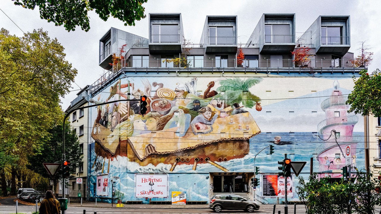 Ein ehemaliger Bunker, jetzt bunt bemalt und mit Wohnungen in den fünf Kuben, steht an einer befahrenen Straße in Düsseldorf-Bilk.