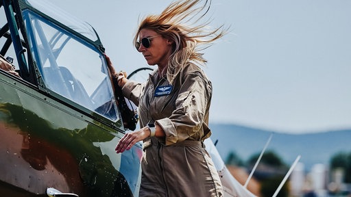 Antonia Schuhmann steigt mit wehenden Haaren in ein Flugzeug ein.