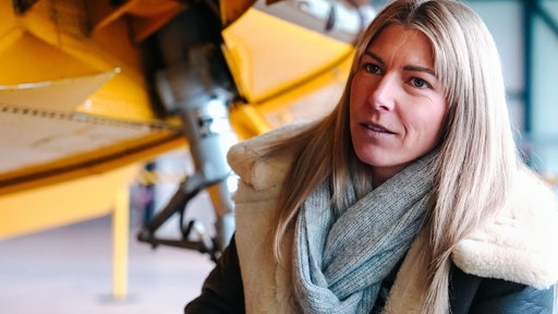 Antonia Schuhmann vor einem Flugzeug.