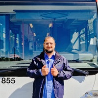 Serhat Yeschil steht vor einem Bus und hält seine Daumen hoch